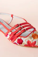 Bailarinas destalonadas celestes con bordado floral multicolor, tiras rojas con hebillas y suela de cuero.