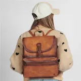 Mochila de diseño elegante, en cuero color marrón, con un compartimento frontal y cierre.