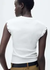 Camiseta negra de tejido de canalé con cuello redondo y sisas con ojales metálicos.