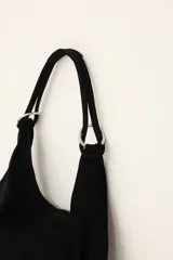Bolso de cuero negro con diseño amplio y cómodo para llevar al hombro.