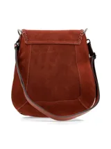 Bandolera de cuero gamuza color chocolate, con correa larga regulable, solapa con detalle de pespuntes y borla decorativa.