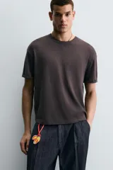 Llavero de cuero con diseño de tres frutas: dos mitades de durazno y una ciruela, con cordón de cuero naranja para colgar. Accesorio de la colección Filipe Jardim x Zara.