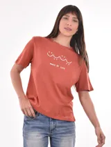 Remera color ladrillo con estampado de olas y texto "Waves of Life" en blanco.