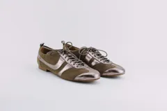 Zapato tipo ballerina acordonado, color marrón con detalles en plateado. Fabricado en cuero.