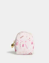 Llavero y charm de mochila color rosa claro, con estampado de productos de maquillaje y tiracierre metálico en forma de corazón dorado.