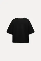 Top negro de punto canalé con cuello redondo y mangas cortas.