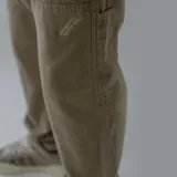 Pantalón de gabardina color marrón con bolsillos laterales y traseros.