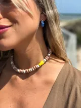 Collar corto con diseño de pez amarillo y cuentas de cerámica, cerrado con cadena de acero quirúrgico.