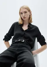 Camisa color crema de manga larga con puños abotonados y cuello camisero.
