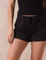 Conjunto de pijama de dos piezas marca René Rofé, compuesto por un top negro de breteles finos y un short con estampado animal print en tonos beige y negro, con cintura elastizada y cordón de ajuste.