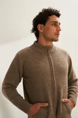 Campera de lana color crema, tejida con cierre delantero, cuello alto y bolsillos delanteros.