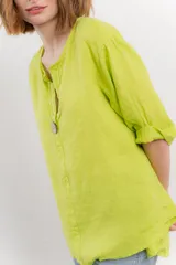 Blusa verde salvia de lino, con escote en V, manga corta y un botón de madera al frente.