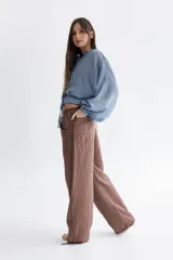 Pantalón marrón de corte ancho, con cintura elástica ajustable con cordón y bolsillos laterales con detalle de flecos.