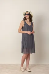 Vestido corto negro de seda con breteles finos anudados en los hombros y escote en V.
