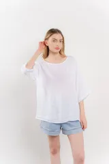 Blusa color beige confeccionada en lino, de corte holgado, mangas 3/4 y cuello redondo.