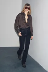 Pantalón de jean azul oscuro, de tiro bajo, corte slim fit y bootcut. Con cinco bolsillos y cierre frontal con cremallera y botón.