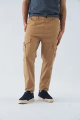 Pantalón cargo color arena, corte slim, con cierre y botón en la cintura, pasacintos y bolsillos cargo con botones.