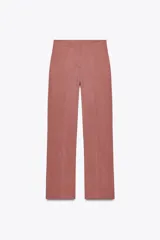 Pantalón de vestir color beige, de tiro alto, con cintura elástica en la parte trasera, bolsillos delanteros y falsos bolsillos de vivo en la parte trasera.