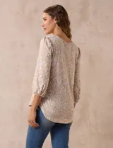 Blusa estampada color beige con cuello redondo calado y mangas 3/4 abullonadas con terminación elastizada.