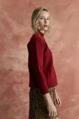 Sweater rojo de punto con cuello alto y diseño de rombos en el frente.