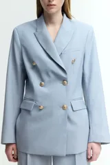 Blazer celeste de doble botonadura con solapas de pico, hombreras finas, bolsillos delanteros ribeteados con solapa y puños abotonados con abertura decorativa. Forrado.