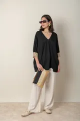 Blusa italiana color crema, tipo poncho, con escote en V con lurex, mangas 3/4 y puños ajustados.