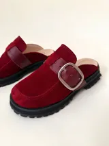 Zueco de cuero vacuno color borgoña con hebilla metálica y suela track negra.