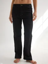 Pantalón negro de gabardina con alforzas verticales en los laterales y aberturas en el ruedo.