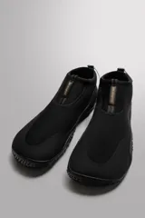 Zapato técnico negro para actividades deportivas en entornos acuáticos. Parte superior fabricada en tejido técnico con puntera y talón recubiertos para proteger de la abrasión. Ajuste mediante pieza técnica y suela Vibram® de goma.