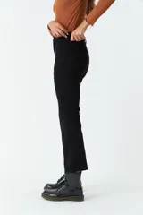 Pantalón de pana negro, de corte recto y tiro medio, con bolsillos y presillas para cinturón.