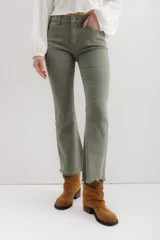 Pantalón jean marrón acampanado con detalle desflecado en el bajo y tiro medio.
