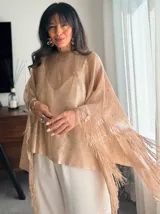 Poncho color dorado tejido en hilo con flecos.