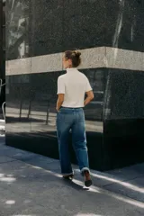 Chaqueta azul marino de punto con cuello subido y manga corta. Cierre frontal con botones.