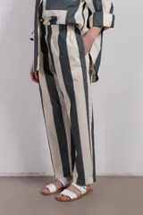 Pantalón recto de tiro medio con cintura elástica y corte holgado. Diseño a rayas verticales en tonos verde y blanco.