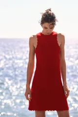 Vestido corto rojo de punto suave con acanalado horizontal, escote redondo, falda evasé y ribetes festoneados.