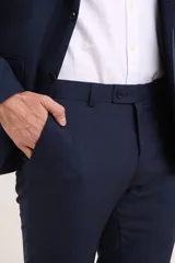 Traje de vestir azul marino, compuesto por saco de dos botones y pantalón de corte slim. Incluye camisa blanca de vestir y zapatos marrones acordonados.