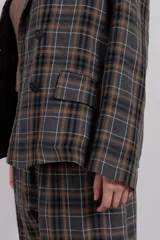 Blazer de corte relajado con estampa tartán, diseño cruzado y hombros caídos.