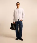 Camisa blanca de algodón, manga larga con botonadura frontal y cuello camisero.