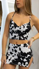 Top corto con estampado de vaca en blanco y negro, con breteles finos y escote drapeado.