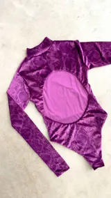 Body de terciopelo marrón con estampado de piel de serpiente, cuello alto, mangas largas con orificio para el pulgar y espalda descubierta.