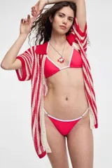 Top de bikini azul con ribete blanco y tirantes finos.