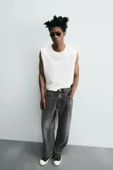 Pantalón de jean gris oscuro, corte amplio, con cinco bolsillos, efecto lavado y cierre frontal con cremallera y botón.