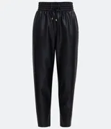 Pantalón zanahoria color marrón claro confeccionado en material sintético con cintura elástica, cordón ajustable con punteras metalizadas, bolsillos laterales y traseros.