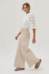Blusa blanca de mangas 3/4 con bordado calado y cuello redondo con volados.
