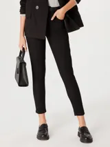 Pantalón de jean negro de cintura media, corte ajustado y largo al tobillo.