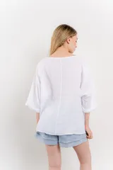 Blusa color beige confeccionada en lino, de corte holgado, mangas 3/4 y cuello redondo.