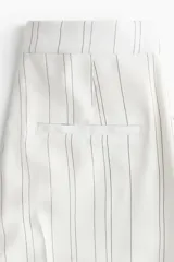 Pantalón ancho de tiro alto con estampado de rayas verticales finas.