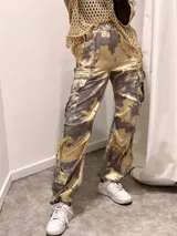 Pantalón cargo de tela satinada con estampado abstracto en tonos dorados y grises.