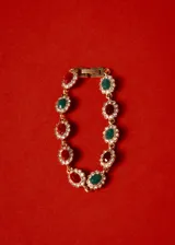 Pulsera dorada con eslabones de bronce y cristales rojos, verdes y blancos engarzados en forma floral.