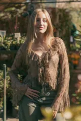 Blusa marrón de encaje transparente con volados en los bordes y mangas globo.